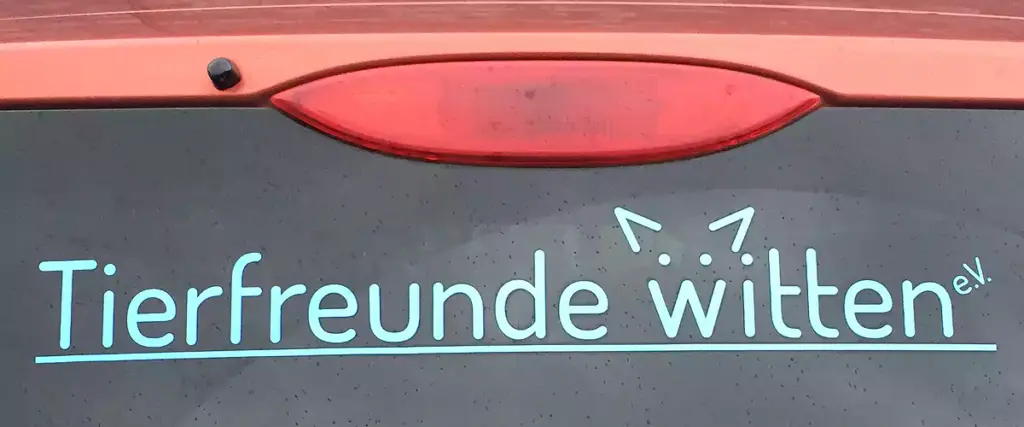 Logo der Heimatfreunde auf der Glasscheibe eines Autos.